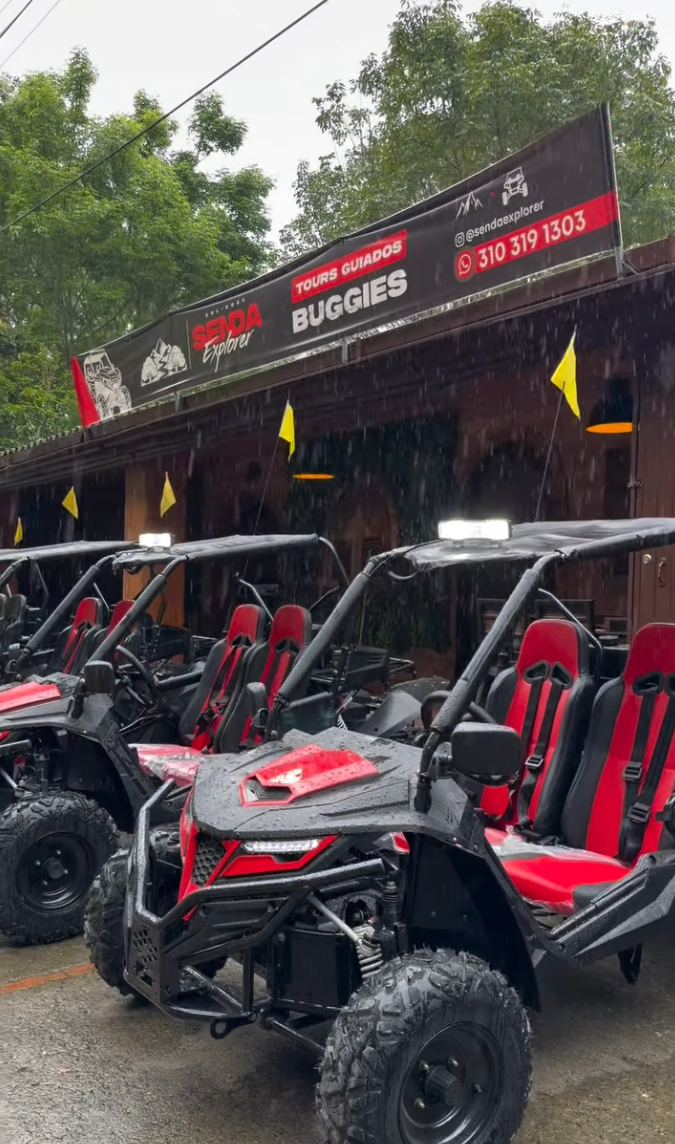 Flota de buggies rojos de Senda Explorer parqueados bajo la lluvia en Choachí