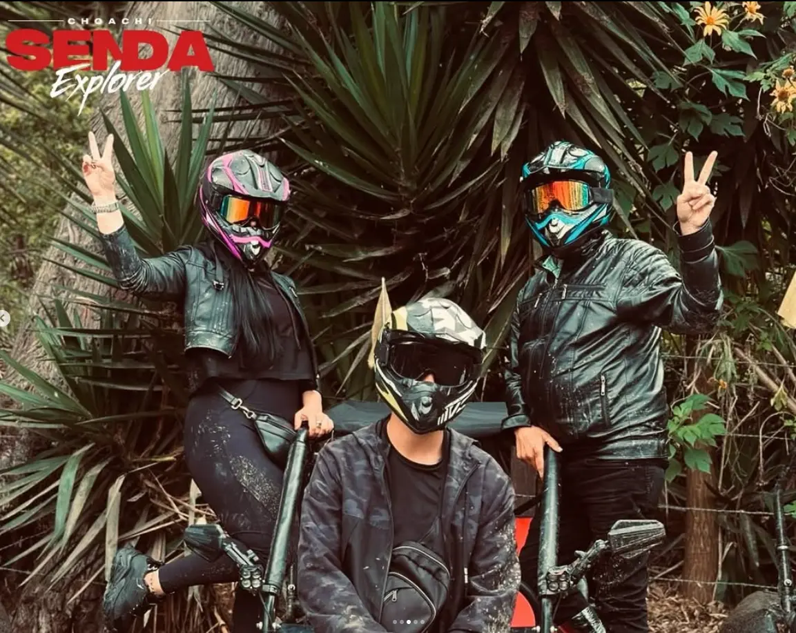 Tres personas con cascos de motocross en medio de la vegetación